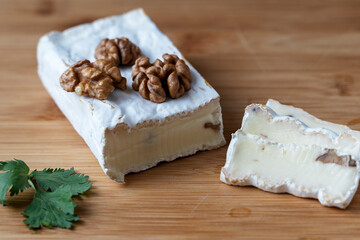 cheese with nuts on a wooden background, the concept of making homemade cheese with walnuts