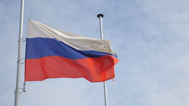Russian flag waving in wind with sky and clouds in background. National flag of Russia. Moscow Flag Blowing Close Up. 4 k video