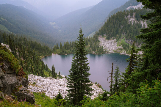 Alpine lake surrounded by trees and granite rock along the pct