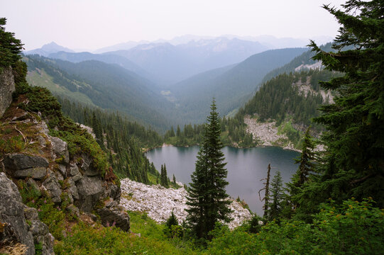Alpine lake surrounded by trees and granite rock along the pct