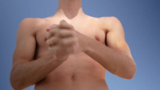 Young man doing wrist rotations as a warm-up before training.