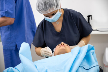 Surgeons performing eyelid surgery to anonymous patient