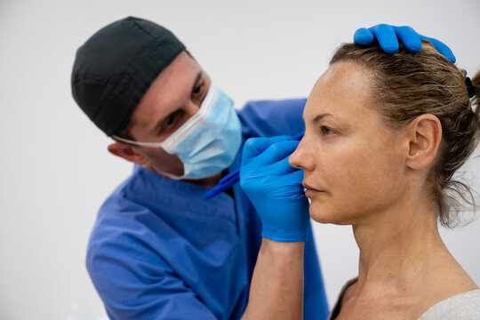 Surgeon drawing line on girl eye with marker preparing for procedure.