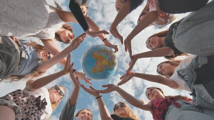 Earth conservation concept. 11 girls surround the rotating earth globe with their palms.