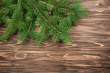 Fir branches on a brown wooden background. Christmas background.