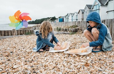 kids eating fish and chips at the beach in the UK