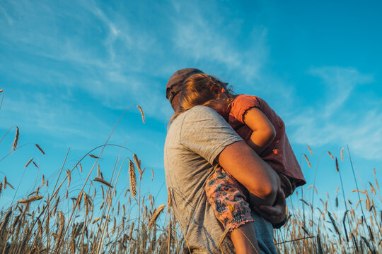 Father playing with his cute little daughter on the field.