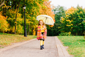 Little child, baby girl laughing and playing in the autumn on the nature walk outdoors