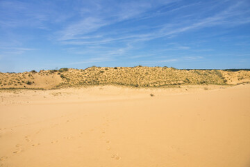 Long sand ridge in the desert under a blue sky