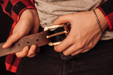 Man putting on an old leather belt