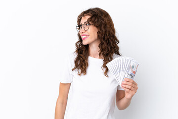 Young woman with curly hair taking a lot of money isolated background on white background looking side