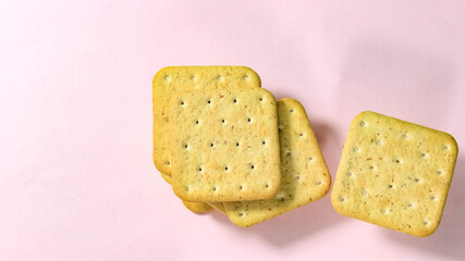 Cookie cracker close-up on a pink background.