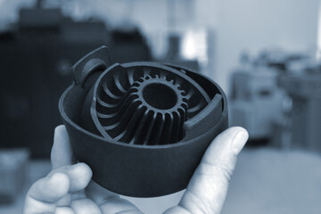 Person holding object printed on professional 3D printer.