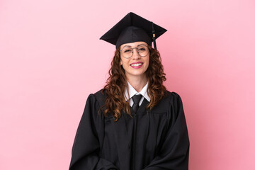 Young university graduate woman isolated on pink background with glasses and happy