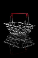 steel wire shopping basket for groceries isolated on a dark background with copy space. concept of black friday sales