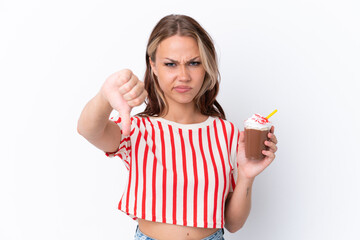 Young Russian girl holding cappuccino isolated on white background showing thumb down with negative expression