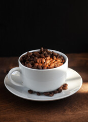 natural coffee beans in a cup on a dark background