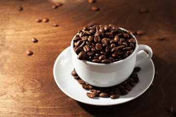 natural coffee beans in a cup on a wood background