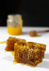 honey spoon, honeycomb and honey jar on dark background