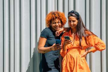 Fototapeta premium friends or girls with mobile phones on the street