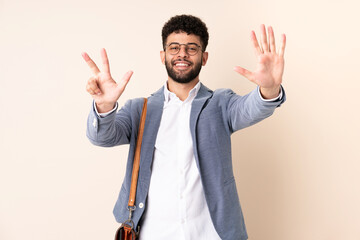 Young business Moroccan man isolated on beige background counting eight with fingers