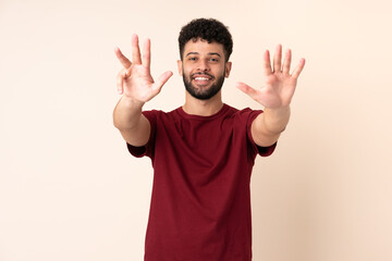 Naklejka premium Young Moroccan man isolated on beige background counting nine with fingers