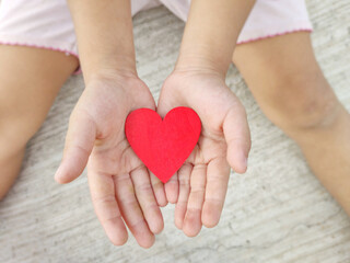 Red heart shaped on palms of hands background. Stock photo.