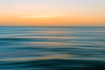 Naklejka na ściany i meble Sunset seascape abstract in bright blue, cyan, yellow colors, motion blur