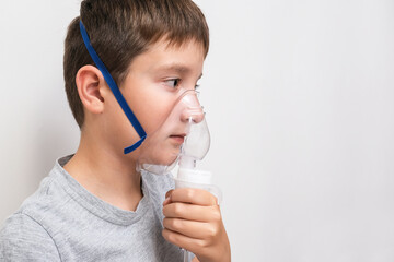 A boy holding on a face an oxigen face mask, pneumonia and lung desease prevention, drug inhalation...