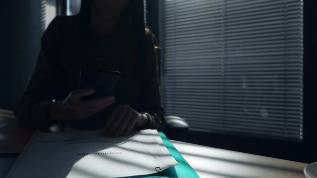 Female employee in espionage concept. Female hands take pictures of confidential documents in the office