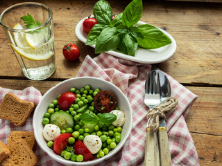 Salad vegetarian. Fresh vegetable salad with tomato, cucumber, basil, green peas, mozzarella cheese.