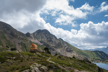 Fototapeta premium Refugio naranja entre montañas y lagos