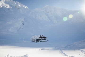 small building in the mountains in winter