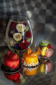 Still life with red and yellow caces, macarons and flowers