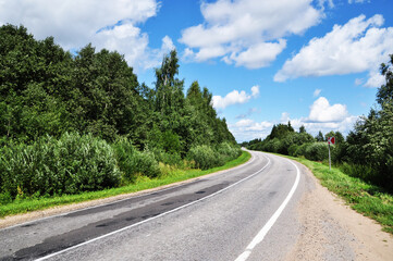 Fototapeta na wymiar Panoramic view of a deserted road. Hit the road. Beautiful clouds in the sky.