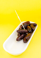 Dried dates on yellow background