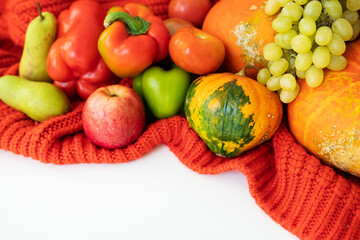 Thanksgiving Day. Big autumn harvest - pear, apples, pumpkin, pepper, tomato on a white background and red cloth. Thanksgiving celebration concept.