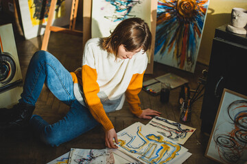 Beautiful woman painting. Girl in Painting Studio. Talented Female Artist Working on a Modern...