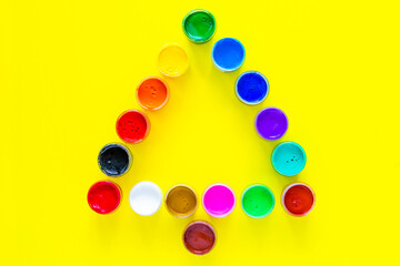 Creative Christmas tree made of paint cans on a yellow background. top view, flat lay, copy space, isolate