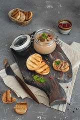 toast with liver pate on a wooden board, homemade liver pate in a glass jar