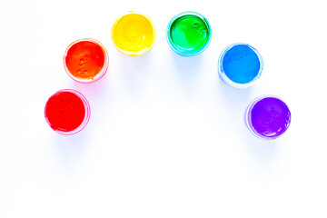 The paint cans are displayed in a semicircle in the form of a rainbow on a white background. top view, flat lay, copy space, isolate.