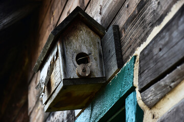 An image of an old hand made wooden bird house. 