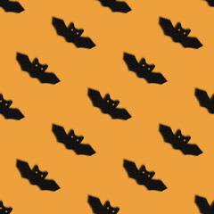 Seamless pattern with bats on orange background. Halloween abstract background.