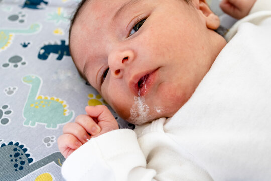 Newborn Baby With Reflux Lying On A Crib Showing The Dangers In Cribs And The Need For Parental Care. Cause Of Death In Preterm Infants In The First Days Of Life. Attention With Special Food.