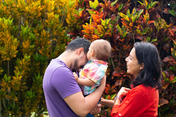 Parents laughing and hugging their child in autumn.Beautiful family three. Orange Rush concept