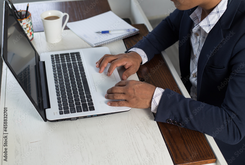 Poster closeup of an adult corporate employee working on his laptop on a desk