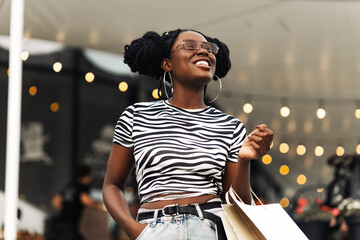 African young woman, walking in the mall with Christmas bags, after Christmas shopping