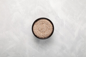 Peruvian seeds chia white in black bowl, top view. Grey background, copy space
