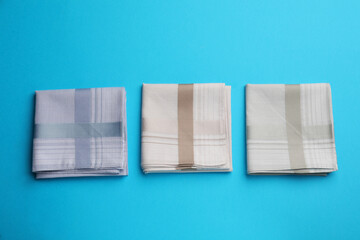 Stylish handkerchiefs on light blue background, flat lay