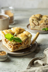 Piece of homemade apple pie with mint leaf on textured background